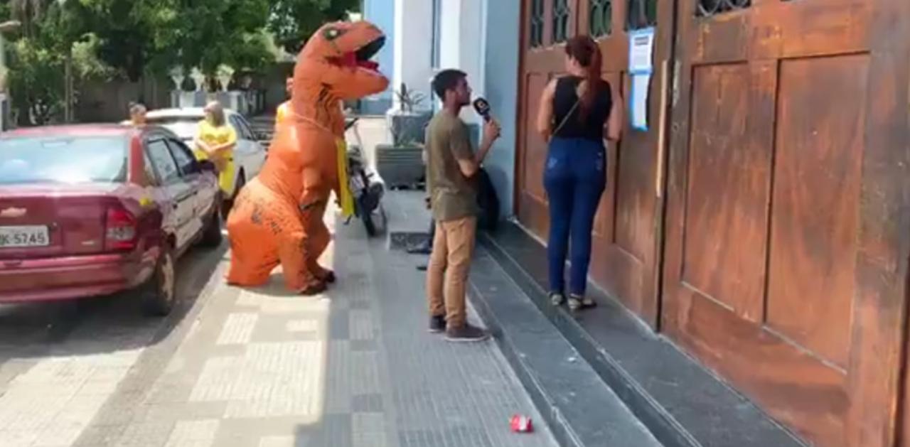 T-Rex aparece na porta do IEA para 'recepcionar' estudante atrasada para o Enem T-Rex aparece na porta do IEA para 'recepcionar' estudante atrasada para o Enem