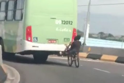 Garotos pegam ‘carona’ de bicicleta encostada em ônibus durante passagem por viaduto de Manaus